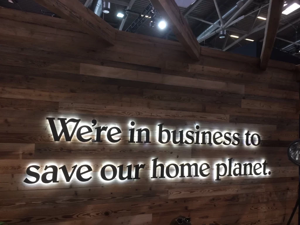 Signage on a wall inside a business office that says 'We're in business to save our planet.'